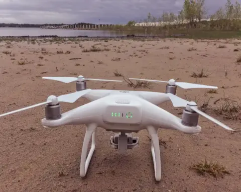 Quadcopter drone resting on a sandy shoreline