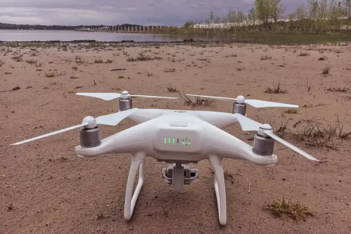 A DJI Phantom quadcopter powered up on open ground.