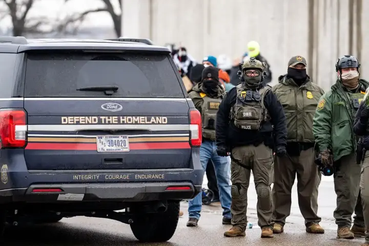 An SUV marked 'Defend The Homeland' parked on a street.