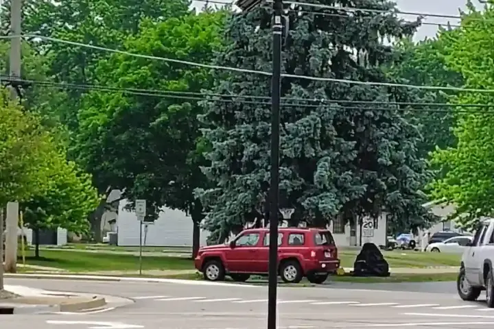 A Flock Safety automated license-plate reader camera mounted on a pole in a quiet residential neighborhood.