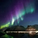 Vibrant green aurora borealis northern lights display across dark night sky during G2 geomagnetic storm event