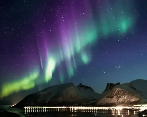 Vibrant green aurora borealis northern lights display across dark night sky during G2 geomagnetic storm event