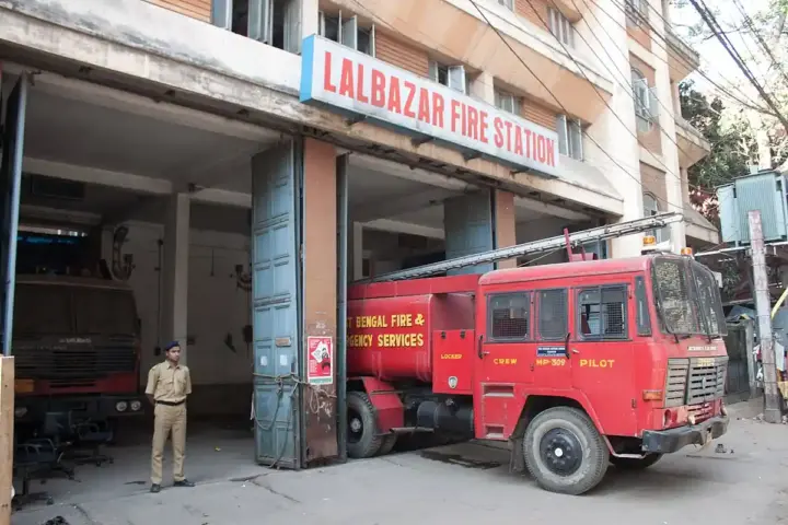 The Lalbazar Fire Station in Kolkata with West Bengal Fire & Emergency Services engines parked outside the building.