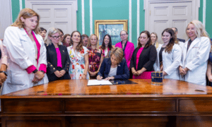 MA Governor signing abortion law with medical staff and advocates at State House
