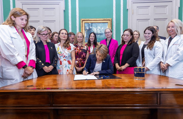 MA Governor signing abortion law with medical staff and advocates at State House
