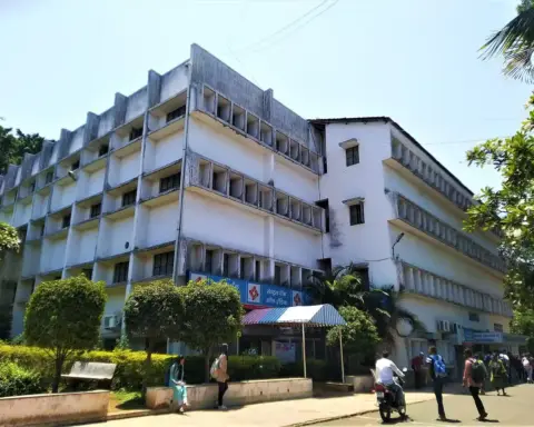 Multi-storey engineering college building in India with students carrying backpacks walking past the entrance.