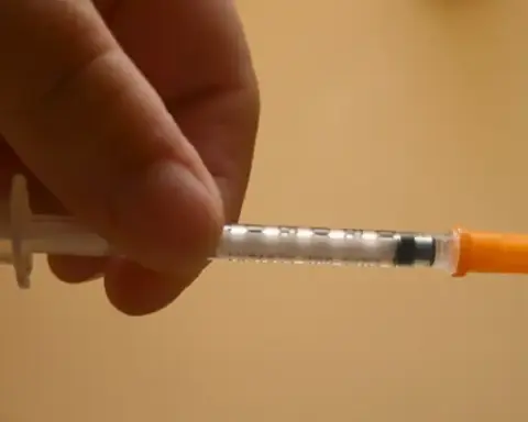 Close-up of an insulin syringe being held before injection representing diabetes treatment and GLP-1 medication use