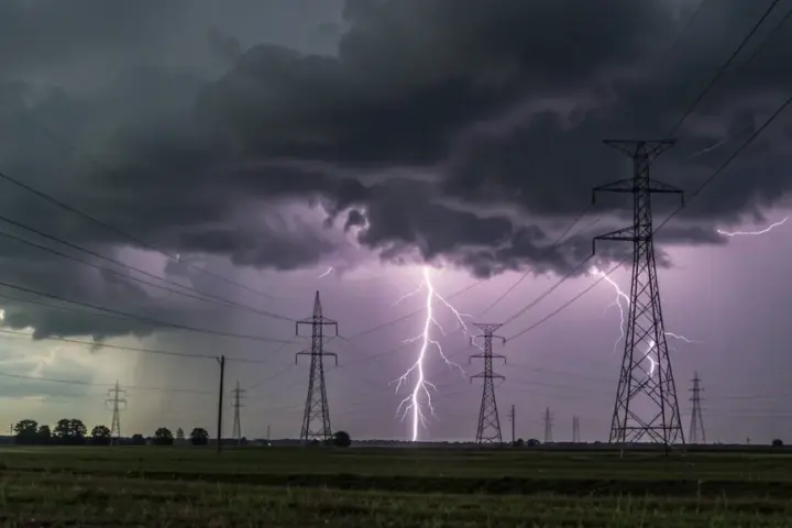 Lightning and storm clouds over rural power lines and transmission towers