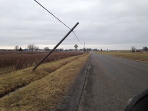 Utility pole leaning after a storm representing power-grid damage