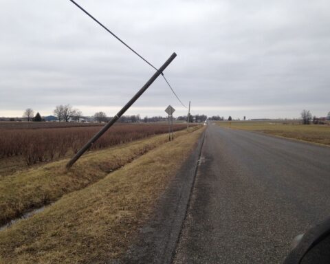 Utility pole leaning after a storm, representing power-grid damage