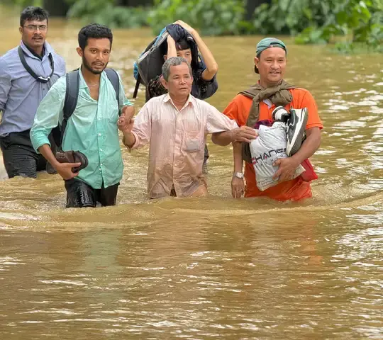 Flood rescue operation in India with people being evacuated through submerged streets by boat