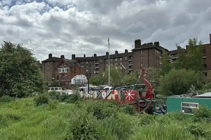 The River Lea waterway winding through East London with moored boats and urban housing in the background
