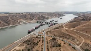Aerial view of the Panama Canal with cargo ships at the locks during low water levels.