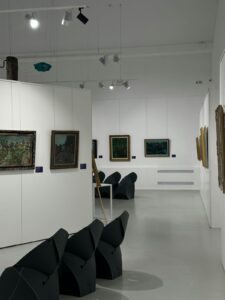 Art gallery interior with paintings displayed on white walls and visitors walking through — illustration of climate activism targeting cultural objects