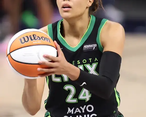 Napheesa Collier holding a Wilson WNBA Finals ball in Minnesota Lynx black jersey, number 24, during the 2024 WNBA Finals at Target Center. Official Wilson Evo NXT Finals ball visible.