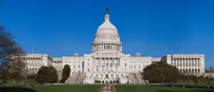 Exterior view of the United States Capitol building in Washington, D.C., showing the western front with its central dome and legislative wings.