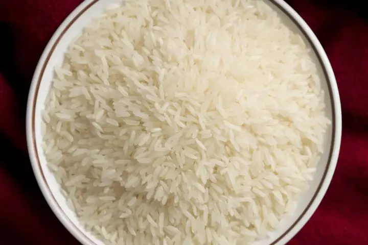 Close-up of uncooked white Thai jasmine rice grains, the type subject to the Lundberg recall.