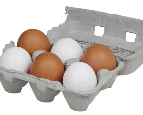 Six chicken eggs, three brown and three white, in an open grey paper pulp half-dozen carton