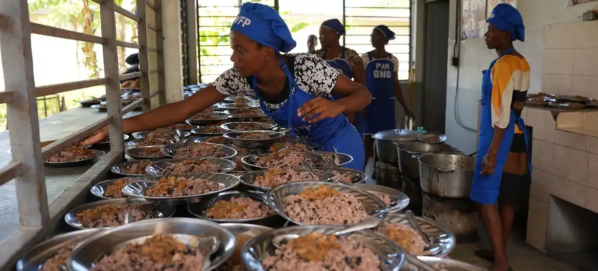 Cooks preparing meals for students in a school kitchen.