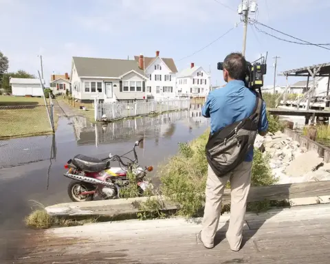 Floodwater covering a residential street and yards in Tangier, Virginia