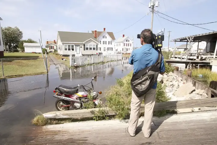 Floodwater covering a residential street and yards in Tangier, Virginia
