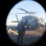 U.S. Navy sailor watches an MH-60R Sea Hawk during operations aboard USS Roosevelt in the Strait of Hormuz.