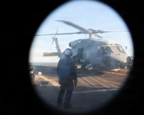 U.S. Navy sailor watches an MH-60R Sea Hawk during operations aboard USS Roosevelt in the Strait of Hormuz.
