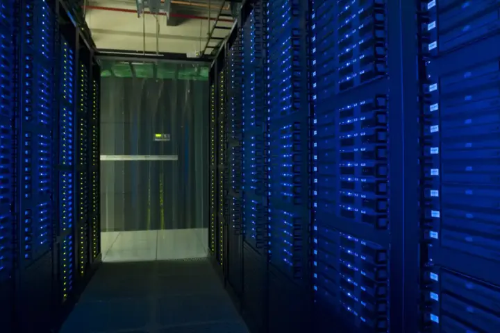 Data center server racks illuminated by blue diagnostic LEDs with structured cabling arrays.