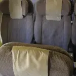 Rows of commercial airplane passenger seats inside a narrow aircraft cabin without visible airline branding