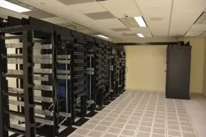 Rows of enterprise server racks and network switches glowing inside a modern cloud computing data facility
