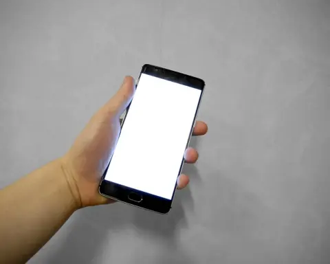 Hand holding a smartphone with a blank white screen