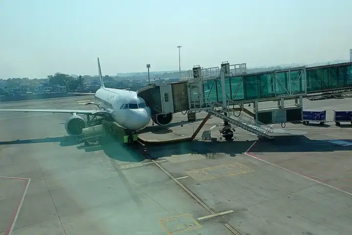 An IndiGo Airbus A321neo aircraft taxiing on the airport runway with engines and airline livery visible.