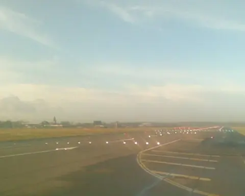Commercial airliners taxiing and operating near the terminal and runway at London Gatwick Airport.