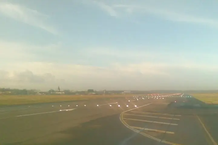 Commercial airliners taxiing and operating near the terminal and runway at London Gatwick Airport.