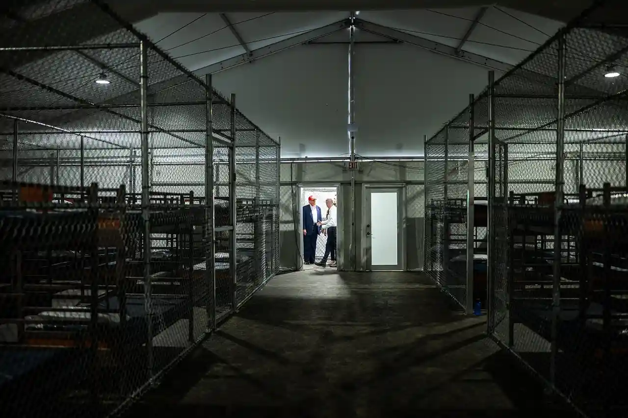 Interior view of the Alligator Alcatraz detention facility showing enclosed areas and rows of bunks.