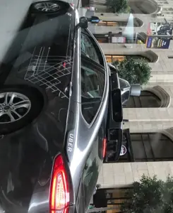 A dark Uber test car parked curbside with an automated navigation rig and lidar spinning sensor mounted on the roof.