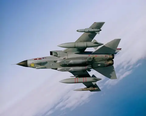 Underside view of a Royal Air Force aircraft in flight carrying two large, grey MBDA Storm Shadow air-launched cruise missiles.