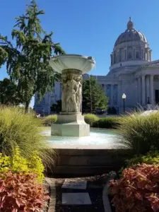Exterior architectural view of the Missouri State Capitol dome and stone portico in Jefferson City.