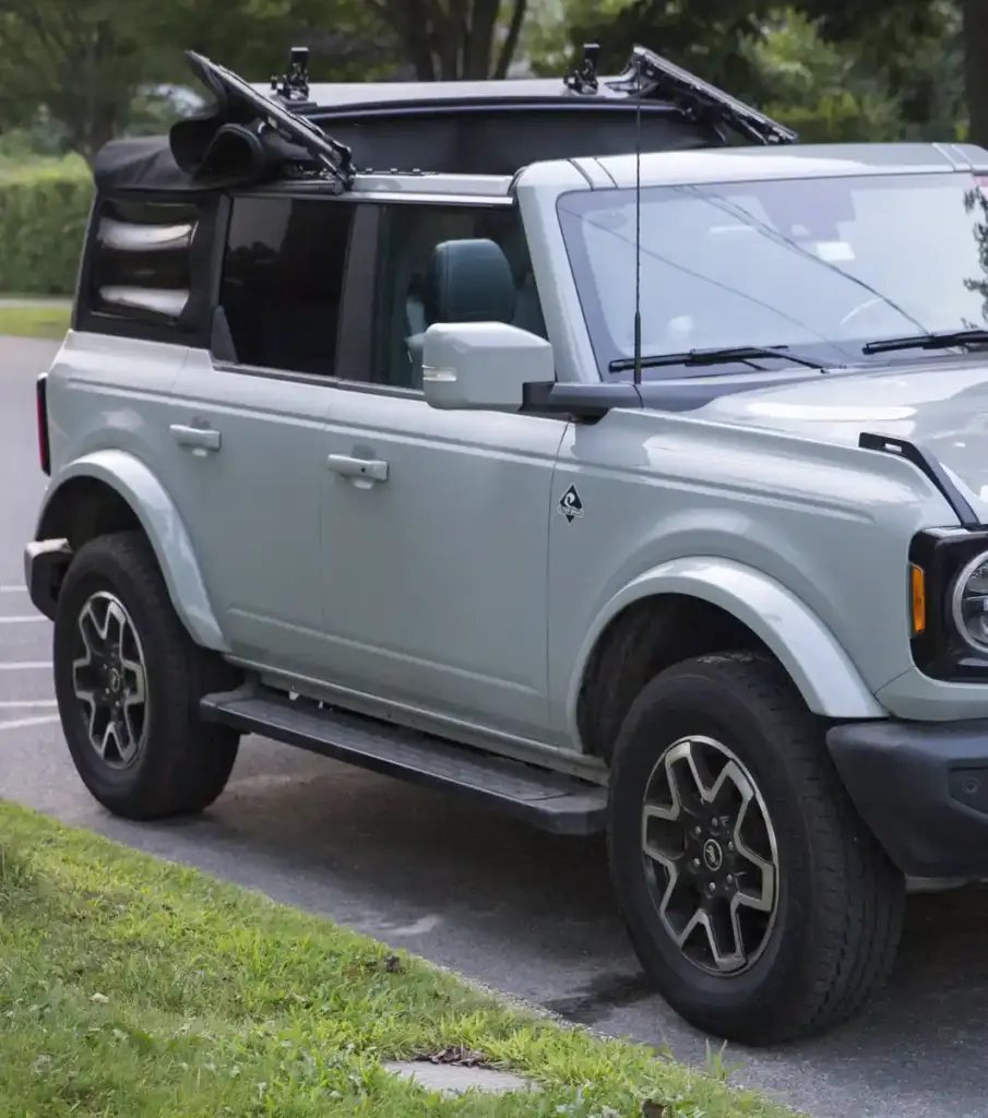 Photograph of a blue four-door Ford Bronco Outer Banks SUV parked outdoors on asphalt.