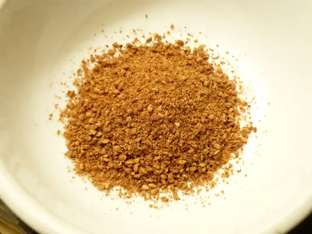 Photograph of unhulled whole sesame seeds placed in a small preparation bowl.