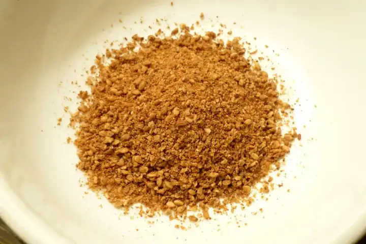 Photograph of unhulled whole sesame seeds placed in a small preparation bowl.