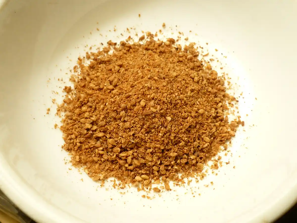 Photograph of unhulled whole sesame seeds placed in a small preparation bowl.