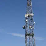 A telecommunications tower with multiple antennas set against the sky.