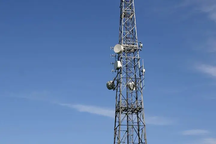 A telecommunications tower with multiple antennas set against the sky.