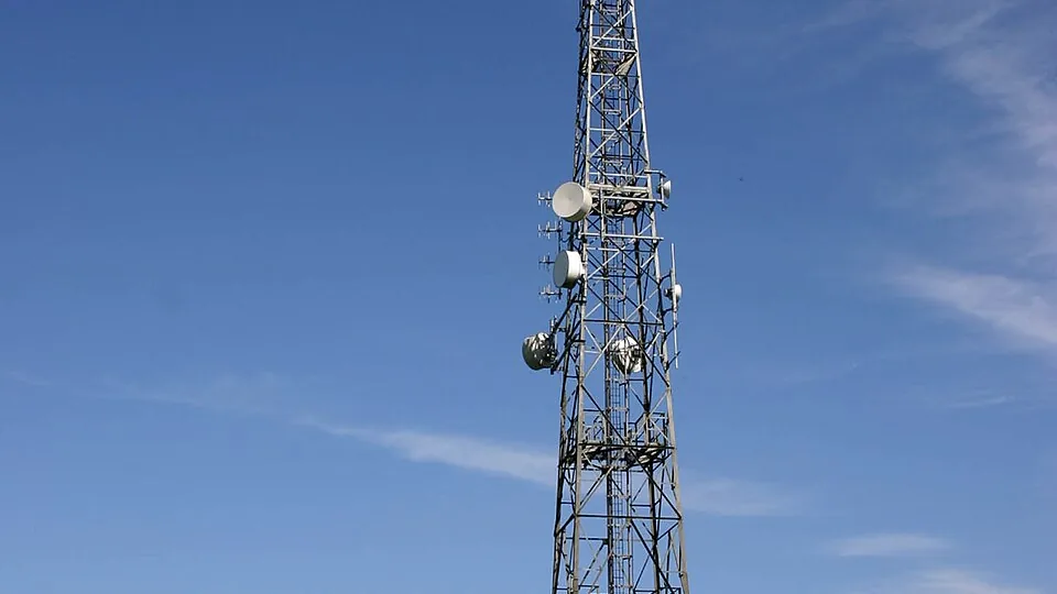 A telecommunications tower with multiple antennas set against the sky.
