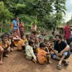 A group of smiling tribal children gathered outdoors in Balaghat district, Madhya Pradesh, during the water crisis that has claimed over 30 young lives.