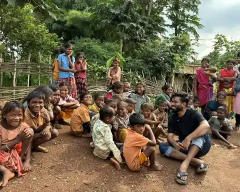 A group of smiling tribal children gathered outdoors in Balaghat district, Madhya Pradesh, during the water crisis that has claimed over 30 young lives.