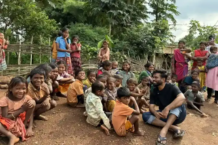 A group of smiling tribal children gathered outdoors in Balaghat district, Madhya Pradesh, during the water crisis that has claimed over 30 young lives.