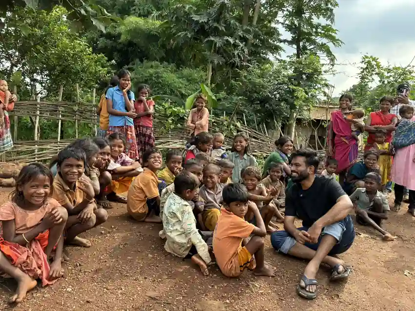 A group of smiling tribal children gathered outdoors in Balaghat district, Madhya Pradesh, during the water crisis that has claimed over 30 young lives.