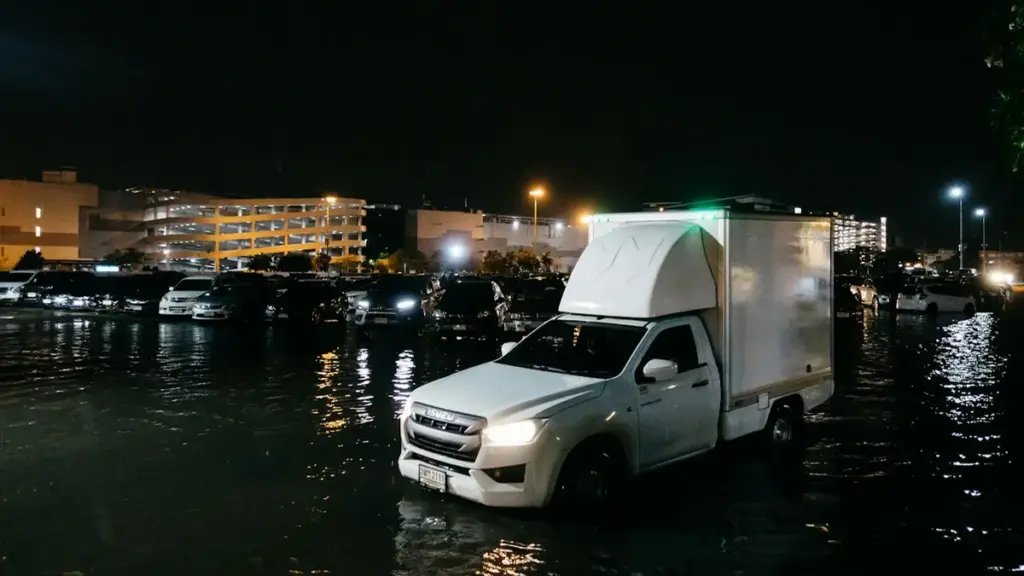 Flooded streets in Bangkok with vehicles submerged during disaster zone declaration